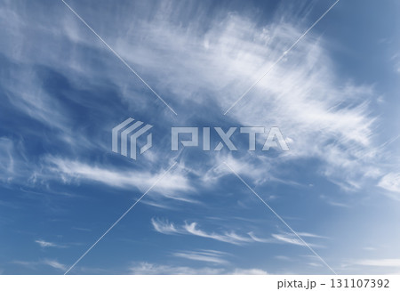 Sky with cirrus clouds. Wispy white streaks in blue atmosphere, soft daylight cloudscape with calm Sky with cirrus clouds. Wispy white streaks in blue atmosphere, soft daylight cloudscape with calm 131107392