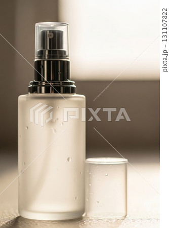 Elegant White Glass Spray Bottle with Silver Accents near Window in Soft Light 131107822
