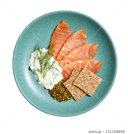 Delicious Garnished Salmon Gravlax with Dill Cream, Pickled Mustard Seeds, and Rye Crisps on a Vibrant Plate 131108808