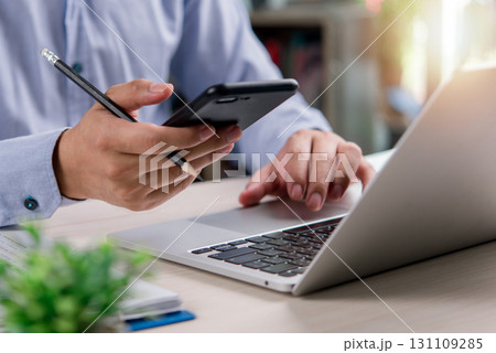 business professional planning and managing tasks with a laptop and smartphone, symbolizing teamwork, entrepreneurship, and business growth. business professional planning and managing tasks with a laptop and smartphone, symbolizing teamwork, entrepreneurship, and business growth. 131109285