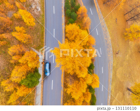 Drone view of a road with car. Asphalt road in the middle of the forest. Autumn landscape 131110110