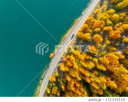 Winding road along the lake. Road near the forest. Drone view of a road with cars.  131110118