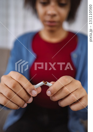 Young woman breaking cigarette and quitting smoking 131110560