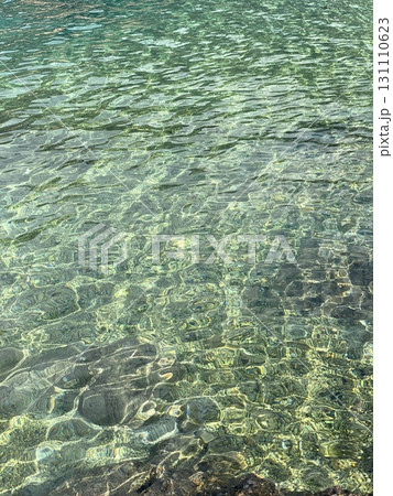 Clear turquoise water surface creating abstract patterns with sunlight reflections and ripples 131110623