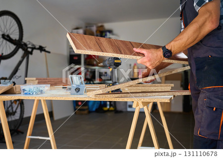 Carpenter assembling wooden furniture parts in workshop Carpenter assembling wooden furniture parts in workshop 131110678