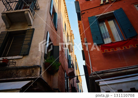 Narrow street with historic buildings and open windows in Venice 131110708