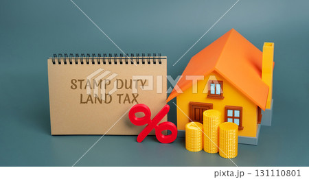 Stamp duty land tax SDLT concept. Taxes assessed during the transfer of real estate between two parties. Buying housing and land. Notes, miniature house and percentage sign with stacks coins Stamp duty land tax SDLT concept. Taxes assessed during the transfer of real estate between two parties. Buying housing and land. Notes, miniature house and percentage sign with stacks coins 131110801