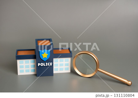 Police building with magnifying glass. Concept of investigation, law enforcement scrutiny, public safety, transparency, crime analysis, and accountability in the justice system. 131110804