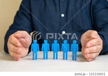 Businessman shields his team with a protective gesture. Symbolizing employee care, life insurance, workplace security and social protection within the company. Safety and human resources. Businessman shields his team with a protective gesture. Symbolizing employee care, life insurance, workplace security and social protection within the company. Safety and human resources. 131110831