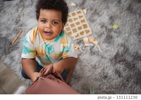 Toddler boy playing alphabet puzzle on fluffy rug Toddler boy playing alphabet puzzle on fluffy rug 131111230