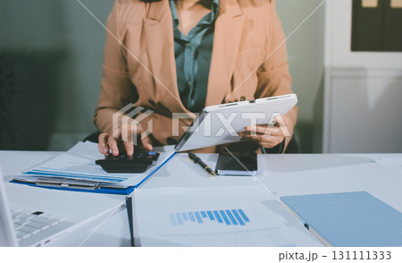 Close-up of businessman's hands making notes, mobiles, chart, desk, office 131111333
