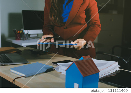 Customer signing a real estate contract in real estate agency. Customer signing a real estate contract in real estate agency. 131111409