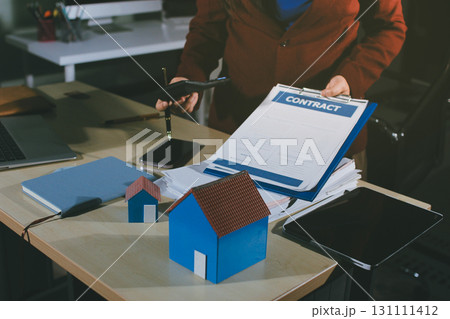 Customer signing a real estate contract in real estate agency. 131111412