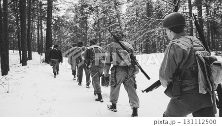 Heroes Of War. Re-enactors Dressed As American Infantry Soldier Marching Through Forest Road In Cold Winter Day. Group Of Usa Soldiers Marching Country Road. Usa Army Soldiers Of World War Ii. black 131112500