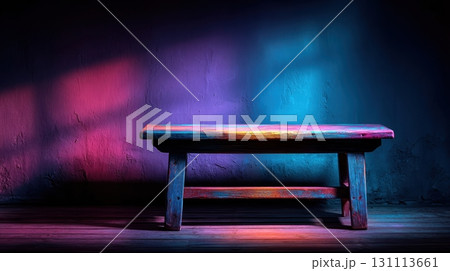 Wooden Table Against Black Wall in Dark Room with Vibrant Colors 131113661