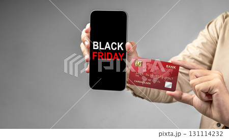 Human hand holding a credit card and a cellphone with the text of Black Friday on the screen. Mockup or Copy space. Black Friday sale concept 131114232