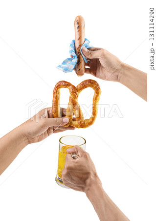 Human hands holding a sausage with a blue checkered tablecloth or napkin, pretzel loaf, and beer mug isolated over a white background. Oktoberfest festival Human hands holding a sausage with a blue checkered tablecloth or napkin, pretzel loaf, and beer mug isolated over a white background. Oktoberfest festival 131114290