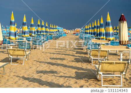 Sun loungers on sandy beach with Umbrellas. Empty seaside resort. Italy. Sun loungers on sandy beach with Umbrellas. Empty seaside resort. Italy. 131114343