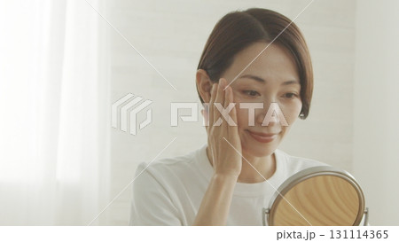 鏡を見ながら肌の調子を確認する40代日本人女性 鏡を見ながら肌の調子を確認する40代日本人女性 131114365