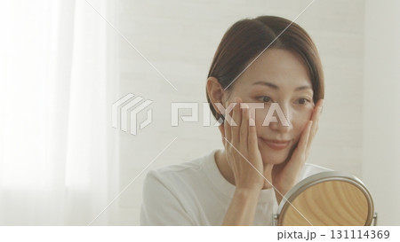 鏡を見ながら肌の調子を確認する40代日本人女性 鏡を見ながら肌の調子を確認する40代日本人女性 131114369