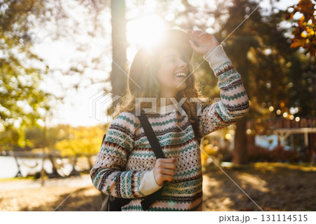 Sunny lifestyle portrait of young stylish woman walking on park, wearing cute trendy hat. Relaxation 131114515