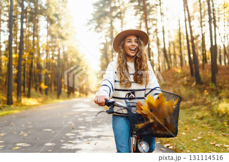 Beautiful woman in stylish clothes with bicycle walking in autumn park Woman walking in sunny forest 131114516