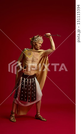 Man in toga raising fork in dramatic gladiator style 131115394