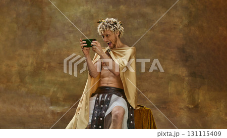 Man in toga playing on smartphone with excited exaggerated reaction 131115409