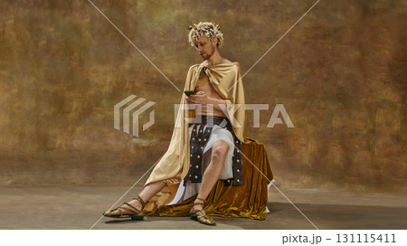 Man in toga sitting with smartphone and concentrated look Man in toga sitting with smartphone and concentrated look 131115411