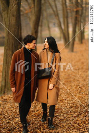 Young couple in love walking in the park on a autumn day. Enjoying time together. Young couple in love walking in the park on a autumn day. Enjoying time together. 131115760