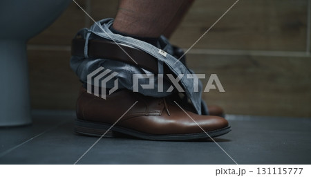 Close Up Shot of Man Taking Off his Pants, Sitting on the Toilet 131115777