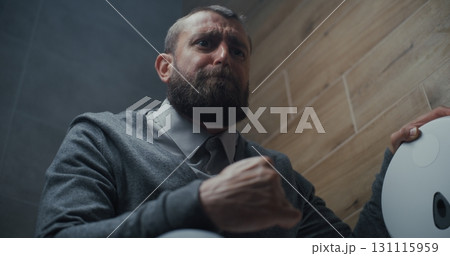 Man Sitting on the Toilet and Suffering from Diarrhea and Stomach Ache in Restroom 131115959