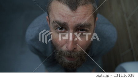 Top View on Man with Tense Facial Expression Sitting on Toilet, Suffering from Diarrhea 131116039