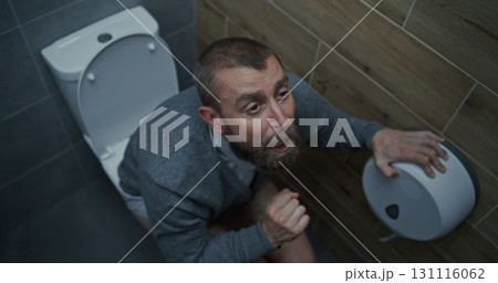 Businessman with Tense Facial Expression Suffering from Diarrhea and Indigestion, Sitting on the Toilet Businessman with Tense Facial Expression Suffering from Diarrhea and Indigestion, Sitting on the Toilet 131116062