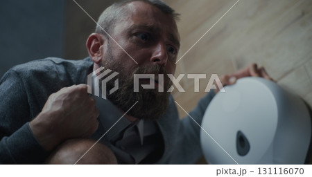 Businessman with Tense Facial Expression Suffering from Diarrhea and Indigestion, Sitting on the Toilet 131116070