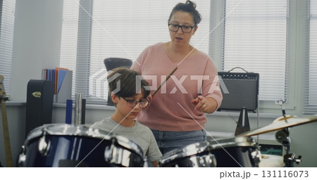 Primary School Boy Practicing Sense of Rhythm, Playing Drums in Music Class Primary School Boy Practicing Sense of Rhythm, Playing Drums in Music Class 131116073