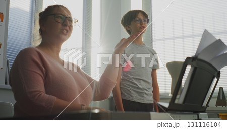 Primary School Boy Practicing Vocals During Singing Lesson. Music Teacher Playing Piano 131116104