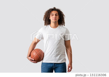 Confident young man holding basketball in casual outfit isolated on white background Confident young man holding basketball in casual outfit isolated on white background 131116306