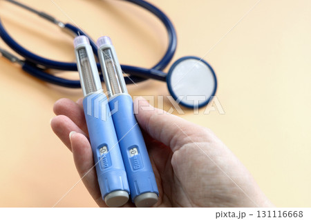 Women's hands holding Insulin injection pen for diabetics and weight loss. 131116668