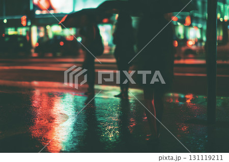 City street at night with silhouettes and neon reflections in the rain 131119211