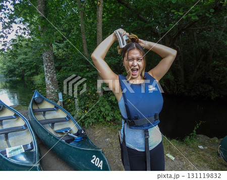 A young woman in getting ready to canoeing a river hold her arms over her head in a victory gesture A young woman in getting ready to canoeing a river hold her arms over her head in a victory gesture 131119832