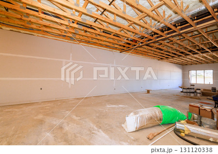 Large room under construction features exposed wooden beams bare walls as workers prepare for finishing touches. Large room under construction features exposed wooden beams bare walls as workers prepare for finishing touches. 131120338