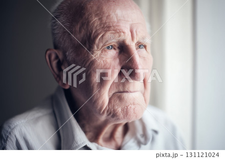 Elderly man looking out the window with thoughtful expression 131121024