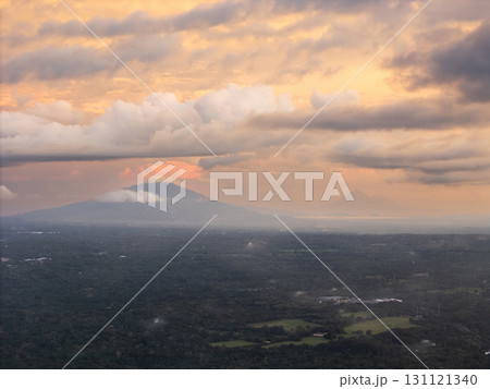 Mountains and clouds at dusk over lush green landscape Mountains and clouds at dusk over lush green landscape 131121340