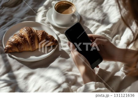Smartphone with coffee cup and croissant 131121636