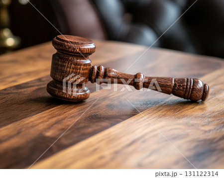 A wooden judge's gavel on a polished table, symbolizing law and justice. 131122314
