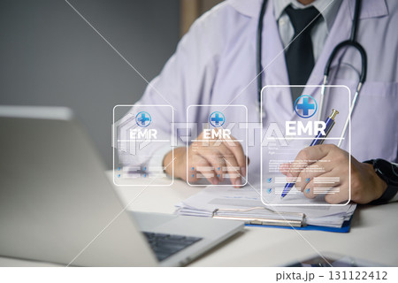 Doctor working on EMR system with digital medical data, healthcare technology, electronic records, and telemedicine concept for modern hospital management. 131122412