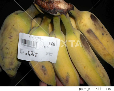 Bunch of Ripe Bananas with a Price Label Showing Weight and Cost on a Dark Background 131122440