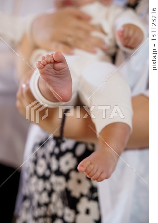 Tender Mother Holding Newborn Baby Feet Close-Up, White Clothing, Black Floral Pattern, Soft Focus, Parental Love, Delicate Skin, Warm Tone 131123216