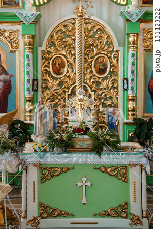 Elaborate Green and Gold Church Altar with Religious Icons, Statues, and Floral Arrangements. Catholic Worship Interior Elaborate Green and Gold Church Altar with Religious Icons, Statues, and Floral Arrangements. Catholic Worship Interior 131123222